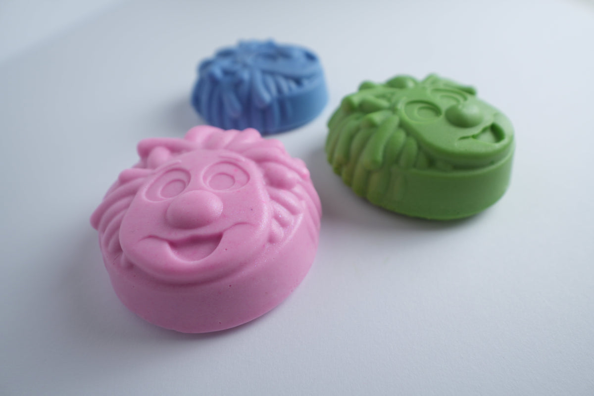 Three Mr. Scrubbadubba soap bars with pink in front